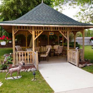 A charming garden gazebo with comfortable seating and lush surroundings.