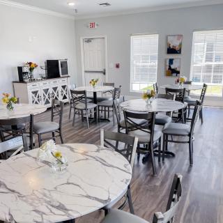 Bright and inviting dining area with marble tables and floral decorations.