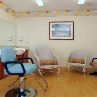 A cozy salon waiting area with comfortable seating and a mirror.