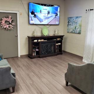 A cozy living room featuring comfortable seating, a mounted television, and stylish decor.