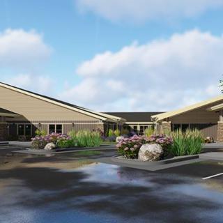 A modern healthcare facility with landscaped surroundings on a sunny day.