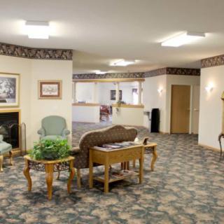 A cozy waiting area with chairs, a table, and wall decorations.