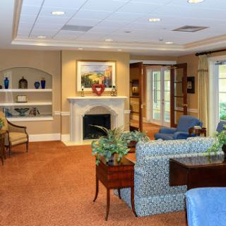 A cozy living room featuring comfortable furniture, a fireplace, and decorative plants.