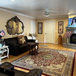A cozy living room featuring a stylish sofa, decorative rug, and elegant mirror.