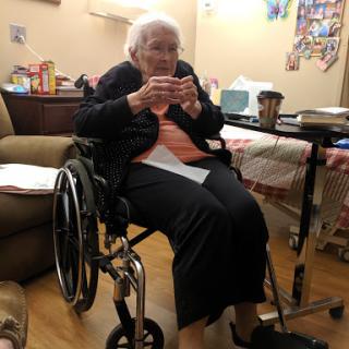An elderly woman sitting in a wheelchair, enjoying her time indoors.