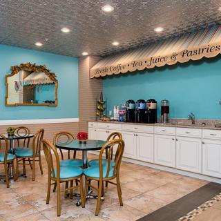 A cozy cafe with tables, chairs, and a coffee station.