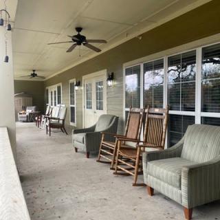 A cozy porch with rocking chairs and armchairs, perfect for relaxation.