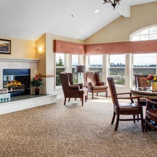 A cozy living room featuring a fireplace, ample seating, and large windows.