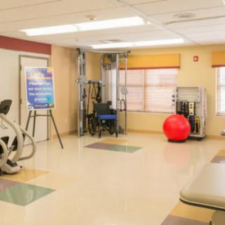 A well-equipped fitness room featuring exercise machines and a large red exercise ball.