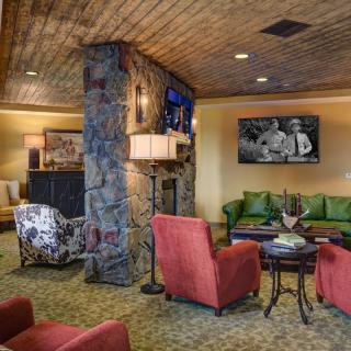 A cozy living room with comfortable seating and a stone fireplace.