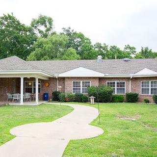 A suburban residential house with a well-maintained lawn and pathway.