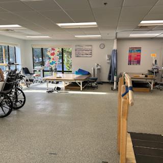 A view of a rehabilitation therapy room equipped with exercise machines and treatment areas.