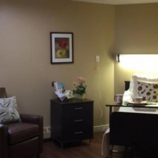 A cozy living room with a chair, side table, and decorative items.