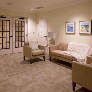 A cozy waiting room with comfortable seating and framed artwork on the walls.