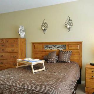 A cozy bedroom with wooden furniture and decorative wall art.