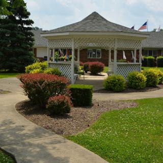 A serene gazebo surrounded by colorful gardens and a winding pathway.