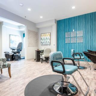 A modern hair salon with stylish blue accent walls and contemporary furnishings.