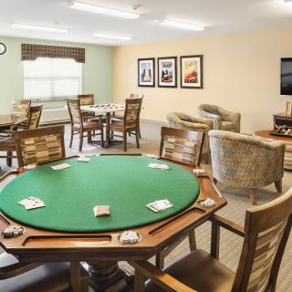 A recreation room featuring a poker table and comfortable seating areas.