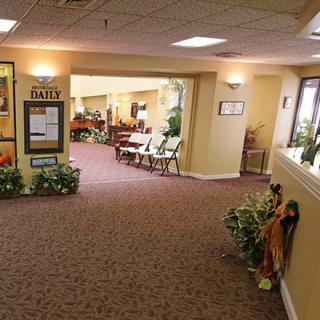 A warmly lit hallway with seating and decorative plants.