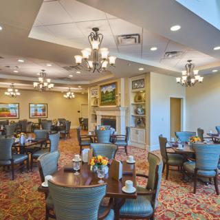 A spacious dining room with elegant furnishings and warm lighting.