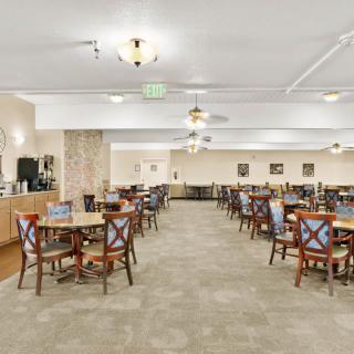 A spacious dining hall with neatly arranged tables and chairs, ambient lighting, and subtle decor.