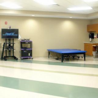 A physical therapy room equipped with exercise tools and a treatment table.