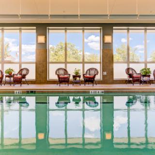 A serene indoor pool area featuring comfortable seating and large windows that bring in natural light.