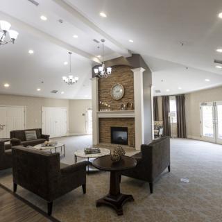 A spacious and modern living room with a central fireplace and elegant furnishings.