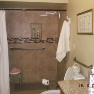 A clean and organized bathroom with a shower, towels, and toiletries.