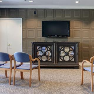 A conference or waiting room with chairs and a television on the wall.