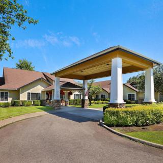 A building with a covered entrance and well-maintained landscaping.
