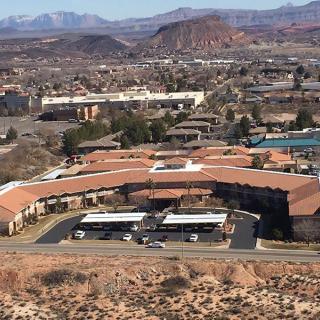 Aerial view of a desert city with buildings and mountains in the background.