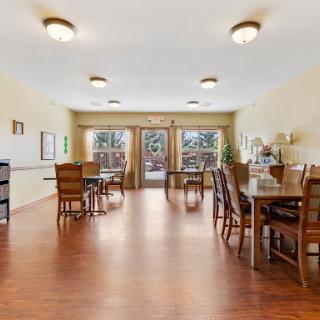 A bright and inviting dining area featuring wooden furniture and ample natural light.