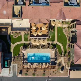 Aerial view of a residential complex featuring a swimming pool and landscaped garden.