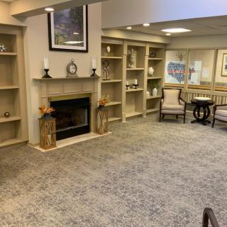 A cozy living room featuring a fireplace, bookshelves, and comfortable seating.