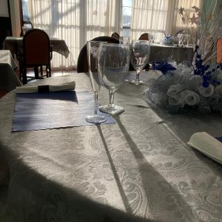 An elegantly set restaurant table bathed in sunlight.