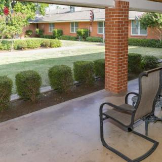 A cozy patio area with chairs overlooking a well-maintained garden.
