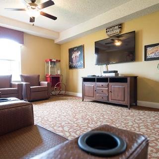 A cozy home theater setup with comfortable seating and a large television.