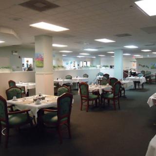 An empty restaurant dining area with neatly arranged tables and chairs.