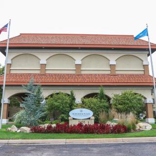 A two-story building with flags and well-maintained landscaping in front.
