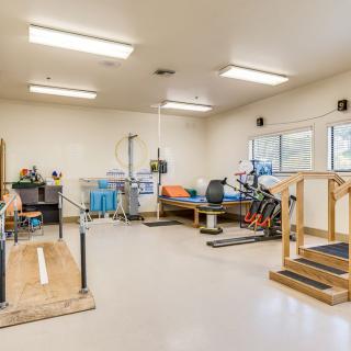 A physical therapy room equipped with various exercise and rehabilitation apparatus.