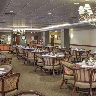 An upscale dining area with elegantly set tables and chandeliers.