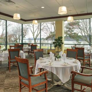 A spacious dining area with neatly set tables and large windows overlooking a scenic view.
