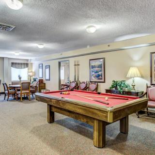 A cozy game room featuring a billiard table and dining area.