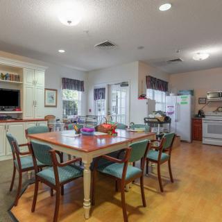 A cozy kitchen and dining area with a large table and chairs, featuring modern appliances.