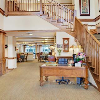 A welcoming lobby area with a wooden staircase and reception desk.