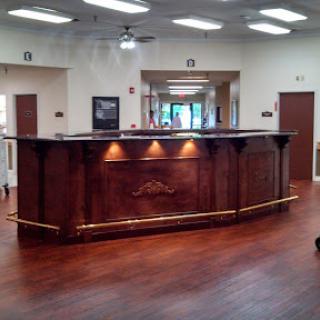 A stylish reception area featuring a wooden front desk and warm lighting.