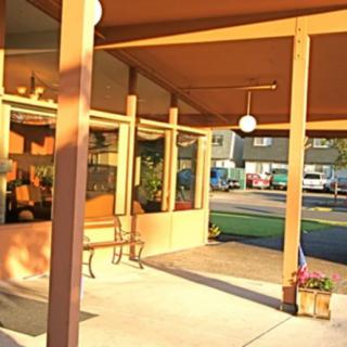 A sunlit entrance of a building with benches and street view in the background.