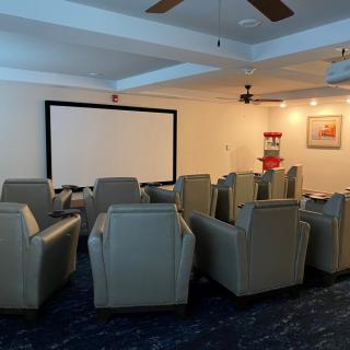 Cozy home theater room with comfortable seating and a large screen.