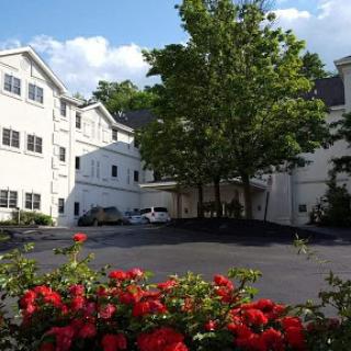A charming hotel surrounded by greenery and vibrant flowers.